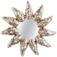 a mirror that has some silver foil on it's face and is shaped like a starburst