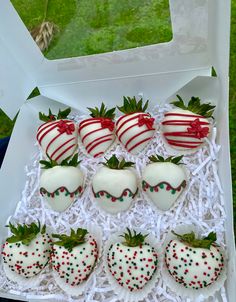 a box filled with chocolate covered strawberries on top of a green grass covered field