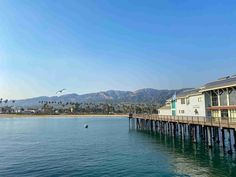 a pier with houses on it and mountains in the background