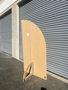 a large wooden object sitting on the side of a building next to a garage door