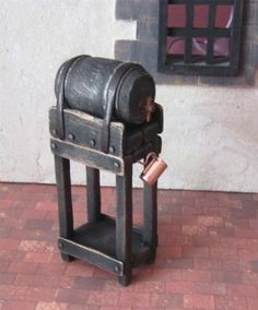 there is a small wooden box with a wine glass in it on the floor next to a brick wall