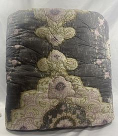 a square pillow with an intricate design on the front and back, sitting on a white surface