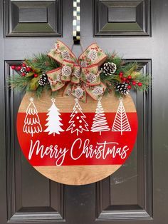 a merry christmas door hanger with pine cones and evergreens on the front door