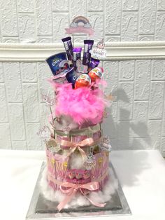 a cake with pink feathers and candy on top