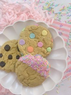 three cookies with sprinkles on a plate