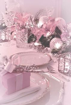 a table set with pink and silver decorations