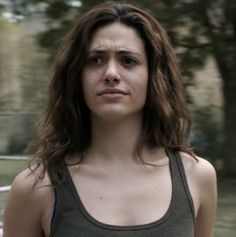 a woman standing in front of a car looking at the camera