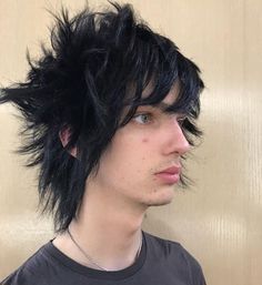 a young man with black hair wearing a t - shirt and looking off to the side