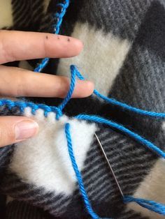 someone is knitting something blue and white