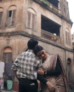 a man and woman standing in front of an old building