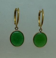 Sku # 9791 Green Jade Earrings Total Number of Jade = 2 Color of Jade = Green Size of Jade = 11.1 x 13.0 mm Shape of Jade = Oval Length in Inches = 1.1 Inches Width in Inches = 0.43 of an Inch Length in MM = 27.6 mm Width in MM = 10.9 mm Gold = 14k Yellow Gold Lock = Hugie Style Jade is natural jade, treated with color enhancers. Impurities are removed and colors are enhanced. A sealing agent reinforces the jade and protects the color treatment. Saturated Blue, Peridot Earrings, Jade Earrings, Black Pendant, Natural Jade, Green Jade, Jade Green, Oval Shape, Jewelry Earrings Dangle