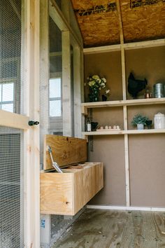 a wooden box sitting on top of a floor next to a shelf filled with pots and pans