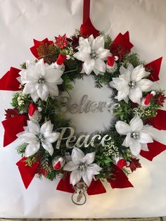 a christmas wreath with white and red flowers