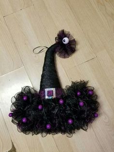 a black witch hat with purple balls on it