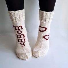 the legs of a woman wearing white socks with red hearts on them and words that spell love