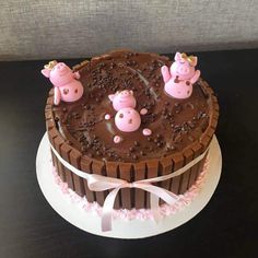 a chocolate cake with three pigs on top