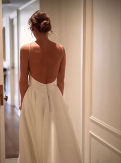 the back of a woman's dress as she walks down a hallway