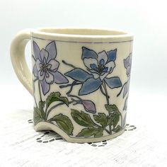 a coffee cup with blue and purple flowers on it