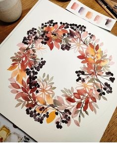 a watercolor wreath is sitting on a table