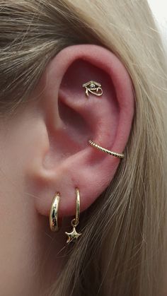 a close up of a person's ear with three different types of piercings