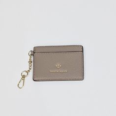 a small card case with a keychain hanging from it's side on a white surface