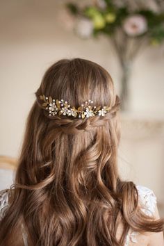 a woman with long hair wearing a gold leaf headpiece