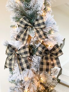 a christmas tree decorated with black and white plaid bows