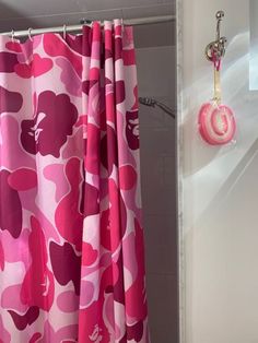 the shower curtain is pink and purple with hearts on it, along with a soap dispenser