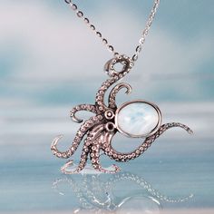 This charming octopus Larimar pendant necklace captures the beauty and mystery of the sea in solid sterling silver and aquamarine Larimar. The sterling silver cable chain fastens securely while the solid 925 sterling silver octopus body forms the perfect setting for the lovely Larimar stone head that evokes the ocean depths. Wear this beautiful and unique octopus necklace to channel the magic of the sea and complement your love of Larimar jewelry and sea animal-inspired designs. The necklace mak Ocean-inspired Silver Gemstone Jewelry, Ocean-inspired Sterling Silver Pendant Jewelry, Body Forms, Octopus Necklace, Larimar Jewelry, Larimar Pendant, Larimar Stone, Body Form, Sea Animal