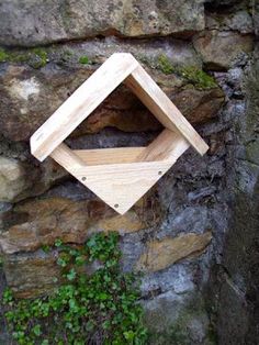 a wooden object sitting on top of a stone wall