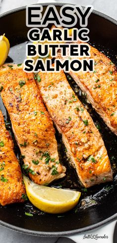 easy garlic butter salmon in a skillet with lemon wedges