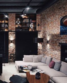 a living room filled with lots of furniture and bookshelves next to a brick wall