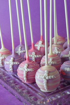 there are many cake pops with white and pink frosting on them