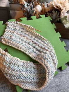 a pair of knitted socks sitting on top of a green mat