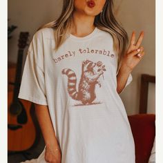 a woman wearing a t - shirt with a raccoon on it