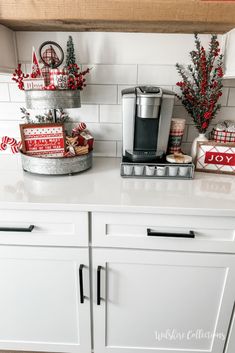 the kitchen counter is decorated for christmas with red and white decorations on it, including coffee maker