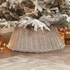 a christmas tree in a wicker basket on the floor