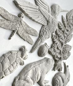 several different types of carved clay animals and birds