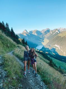 two women standing on the side of a mountain