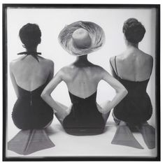 three women sitting on the ground with their backs to each other, facing different directions