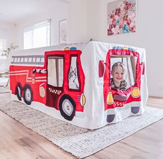 a child's firetruck play tent in the middle of a living room