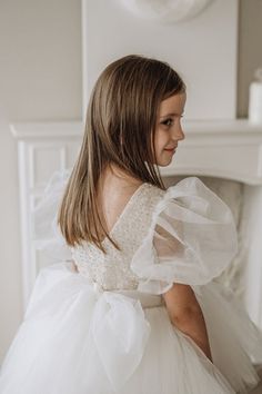 Elevate her special moments with this stunning White Flower Girls Dress 🌸✨. From the intricately beaded front to the enchanting floor-length tulle tail, it's a vision of elegance. Puffy bubble sleeves add a touch of whimsy. Made in Europe, fully cotton-lined for comfort. Perfect for unforgettable moments! 💖 #FlowerGirl Elegant Tulle Ball Gown With Lace Sleeves, Elegant Floor-length Tulle Pageant Dress, Fitted Tulle Pageant Dress For Debutante Ball, Wedding Princess Dress With Lace Sleeves And Tulle, Elegant Princess Dress With Tulle Skirt For Debutante Ball, Elegant Tulle Princess Dress With Pearl Embroidery, Elegant Pageant Dress With Lace Bodice For Debutante Ball, Elegant Princess Dress With Pearl Embroidery And Tulle, Elegant Organza Pageant Dress With Tulle Skirt