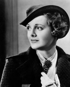 a black and white photo of a woman wearing a hat