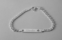 These fashionable bracelets never go out of style!  This pretty sterling silver bracelet is 6 " long and features a little heart cutout on the ID plate.  It has a spring ring clasp, and the identification  plate is about 1" long overall and is 3/16" wide.    Since the engraving area is rather small it will be best to go with initials or a name, and stick with the fifth avenue, block, double line, or miniature script style for the engraving.  To see my current selection of bracelets:https://www.e Silver Engraved Heart Bracelet, Adjustable, Silver Heart Bracelet With Name, Silver Engraved Heart Name Bracelet, Silver Heart Name Bracelet, Silver Charm Bracelet With Name, Silver Name Charm Bracelet, Silver Engraved Bracelet, Hand Chain Bracelet, Delicate Gold Necklace