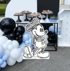 a mickey mouse party with balloons and desserts