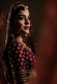 a woman in a red and gold bridal outfit