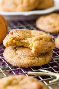 some cookies on a cooling rack with an orange in the background