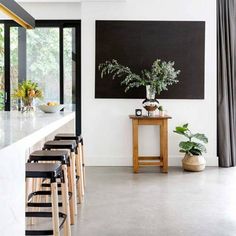 a kitchen with stools and a table in front of a painting on the wall