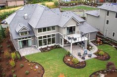 an aerial view of a large house with landscaping and patio area in the foreground