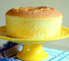 a cake sitting on top of a yellow platter next to a blue and white table cloth